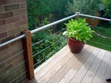 decking balustrade with stainless steel tubular handrail and cable infill